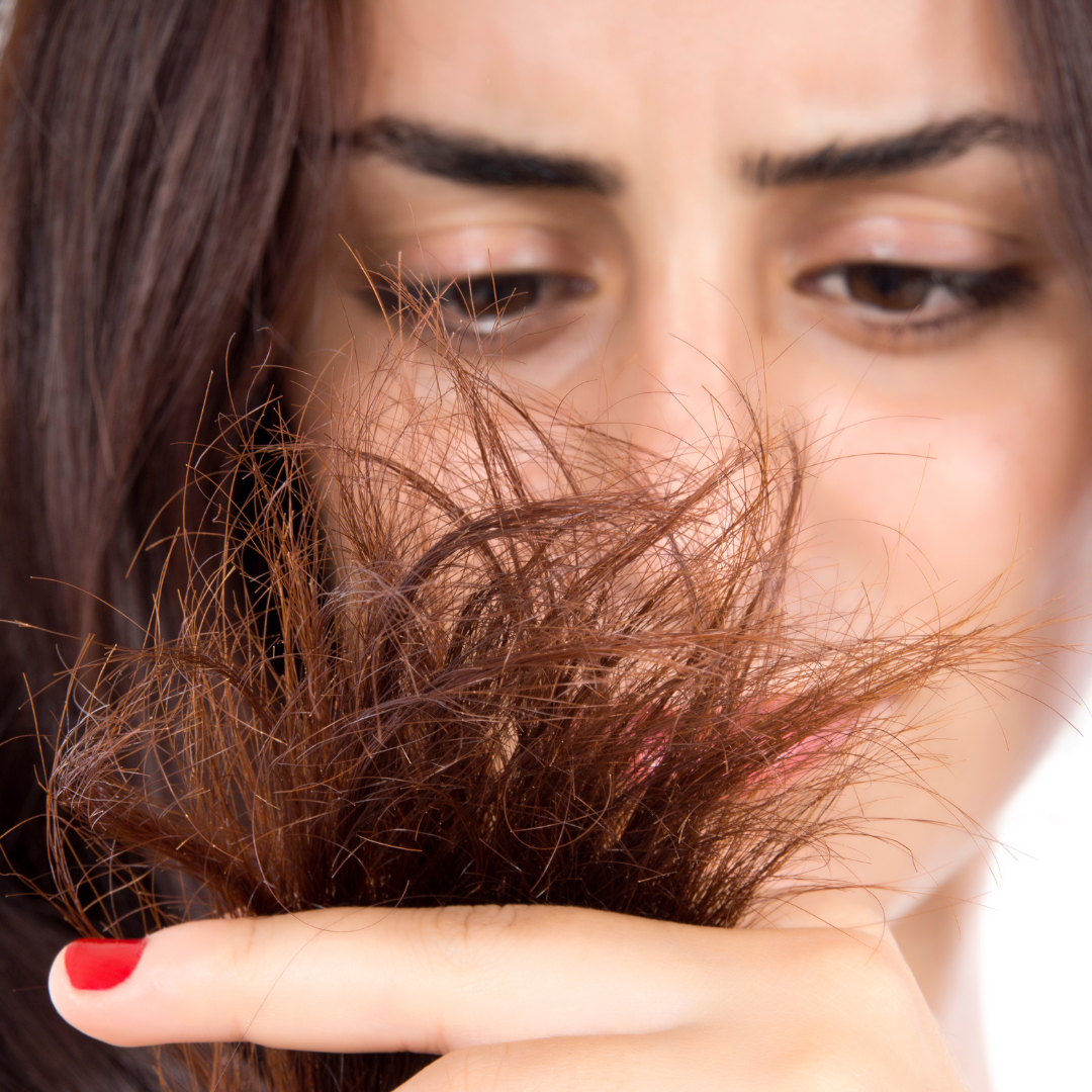 Woman examining dry split ends before CaviarBloom hair treatment